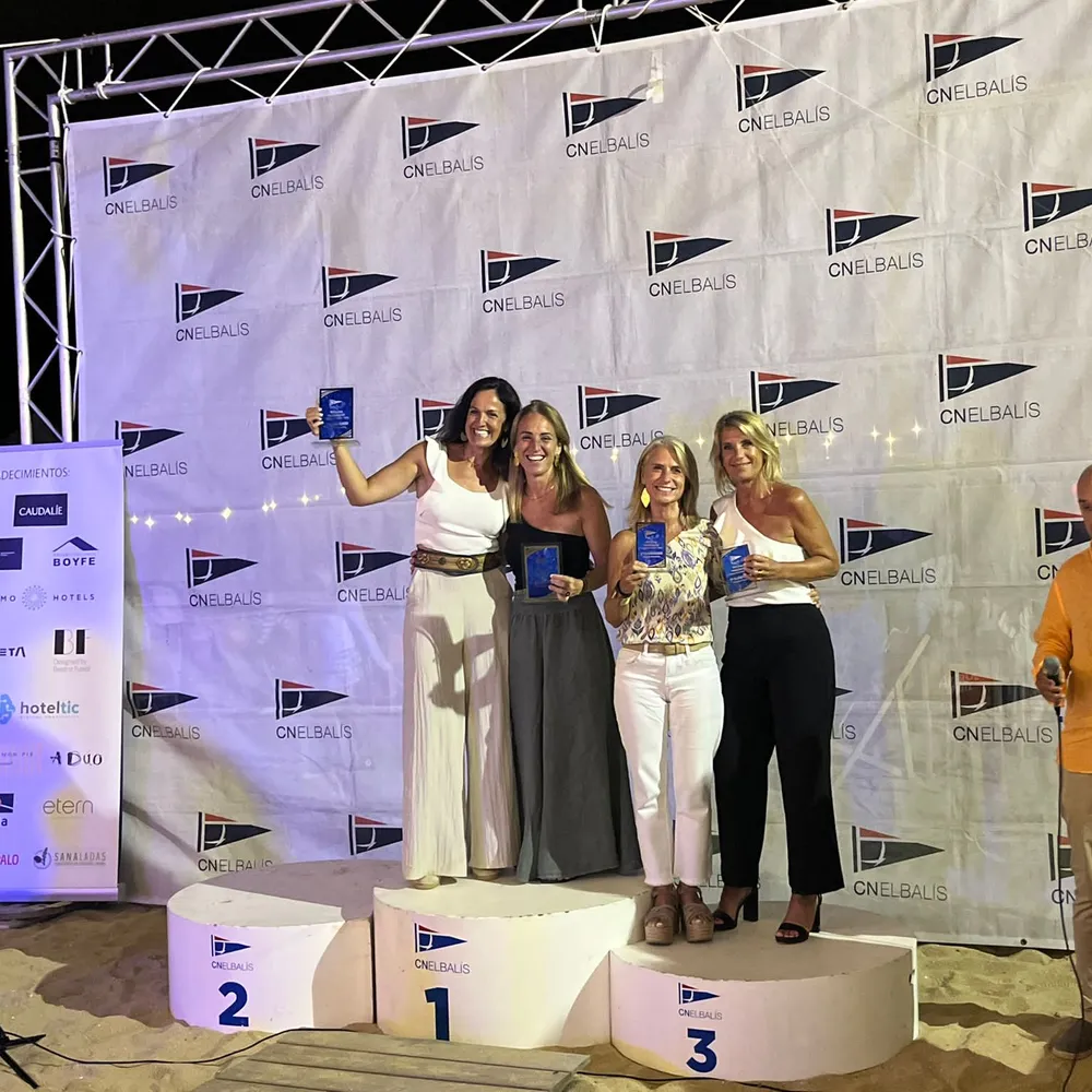 Entrega de premios de la cena de clausura 2024 ante el photocall, con ganadoras en el podio.